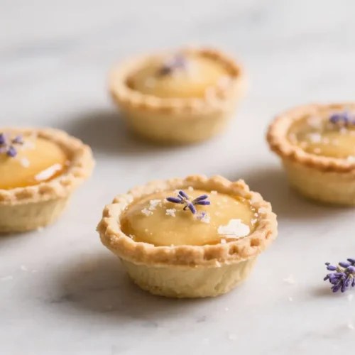 Mini honey lavender pies with flaky crusts, filled with glossy honey custard and topped with sea salt and dried lavender buds.
