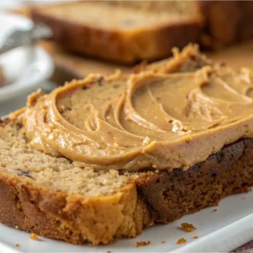 Slice of peanut butter banana bread topped with creamy peanut butter