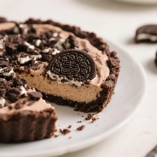 No bake Oreo pie with chocolate cookie crust and creamy cookies and cream filling topped with crushed Oreos