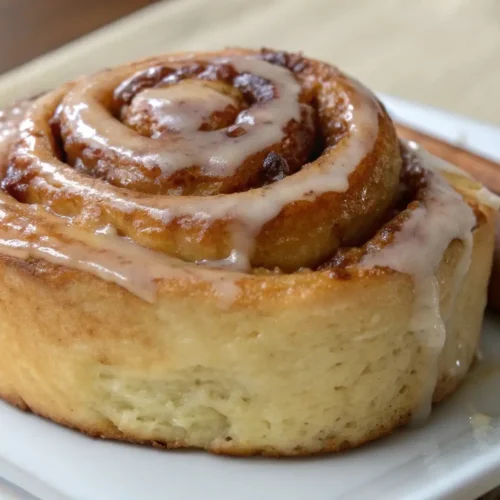 Banana Bread Cinnamon Rolls Easy Homemade Recipe - Soft, Cozy, and Full of Flavor 2 Banana bread cinnamon roll with soft texture and cinnamon glaze on a white plate
