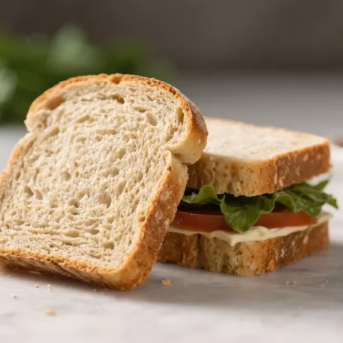 Slices of soft gluten-free bread with an airy crumb, shown plain and as a sandwich with lettuce and tomato.