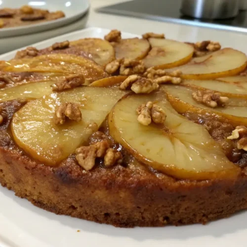 Pear walnut upside-down cake with caramelized pear slices and crunchy walnuts on a moist golden sponge