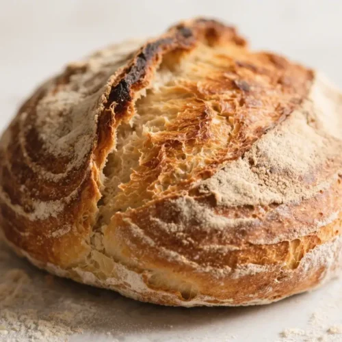 Homemade Rustic Boule Crispy Crust Bread Recipe - Simple, Cozy, and Satisfying 3 Rustic artisan sourdough boule with a golden crust and flour-dusted surface.
