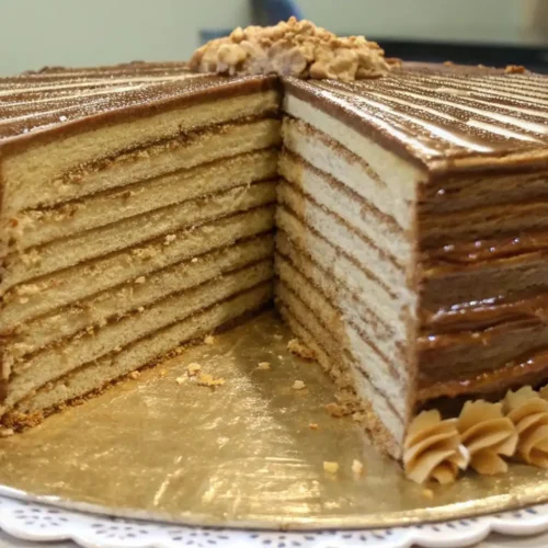 Multi-layer Smith Island cake with thin sponge layers and rich caramel frosting on a serving plate