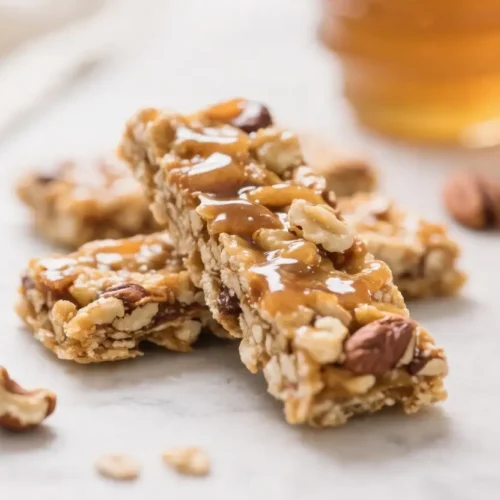 Homemade kind bars with mixed nuts oats and honey drizzled on top served as a healthy no bake snack