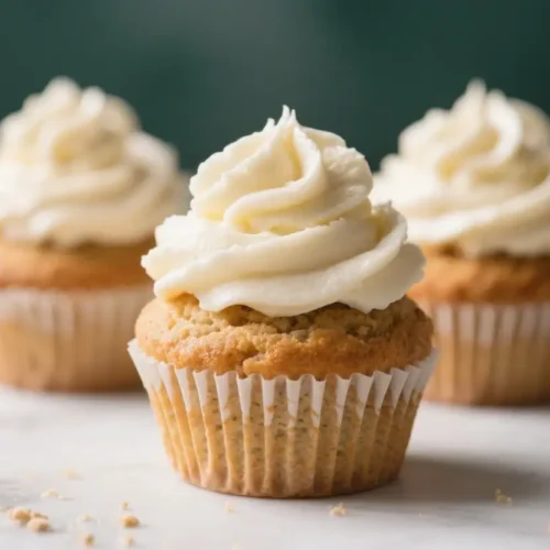Moist Gluten Free Cupcakes With Creamy Frosting - Tender, Flavorful, and Easy 2 Gluten free vanilla cupcakes with creamy buttercream frosting on a light background