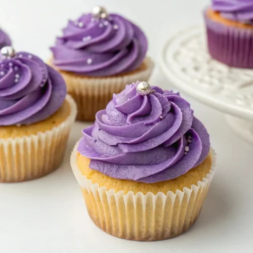 Cute Purple Cupcakes for Weddings, Birthdays and Events - Soft, Elegant, and Easy 2 Purple frosted cupcakes with vanilla base and smooth buttercream swirls topped with silver sprinkles on a white background