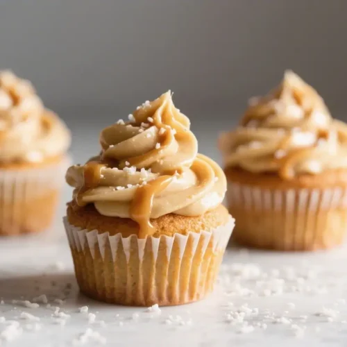 Salted caramel cupcakes with creamy caramel frosting and caramel drizzle topped with sea salt flakes