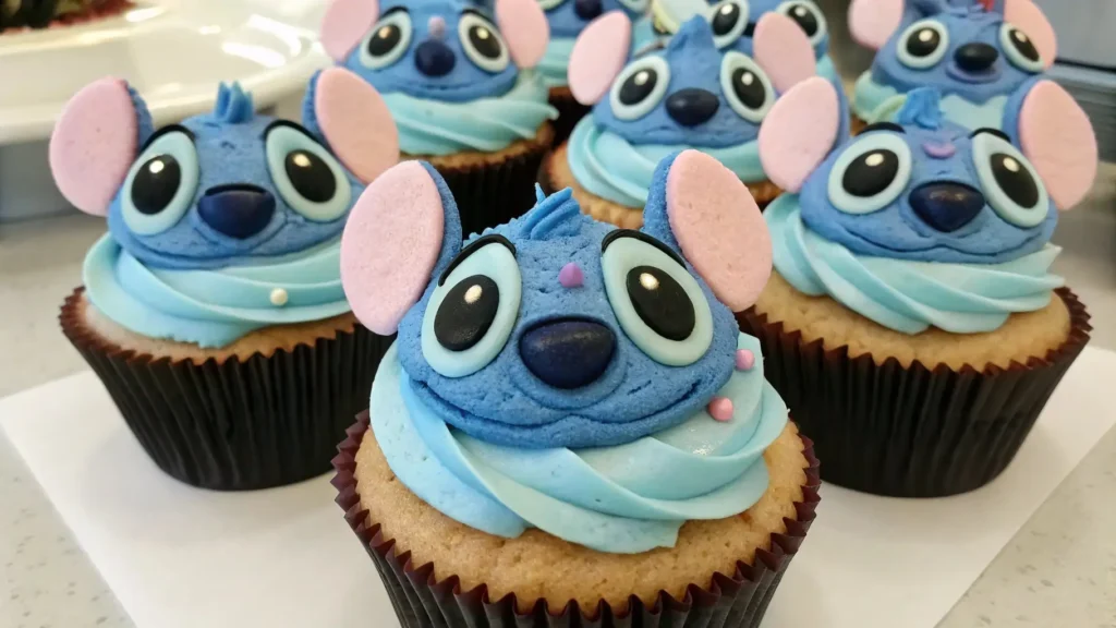 Stitch themed cupcakes with blue frosting and fondant character faces inspired by Lilo and Stitch