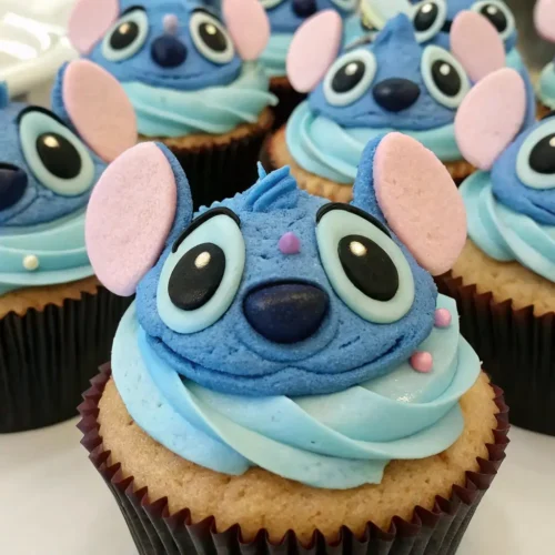 Stitch themed cupcakes with blue frosting and fondant character faces inspired by Lilo and Stitch